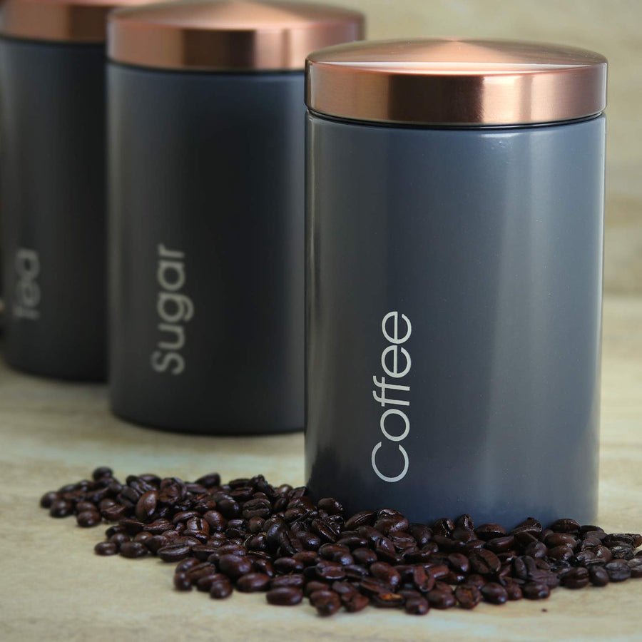 MegaChef Coffee canister in matte gray with copper lid beside coffee beans, Sugar and Tea canisters behind it