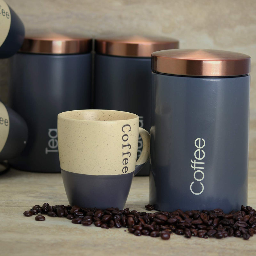 MegaChef matte gray Coffee canister with copper lid on a counter beside a coffee mug and beans, Tea canister behind