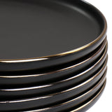 Close up of matte black stoneware plate edge with gold rim