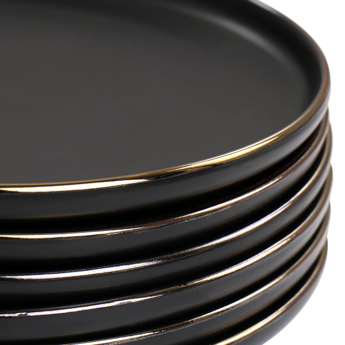 Close up of matte black stoneware plate edge with gold rim