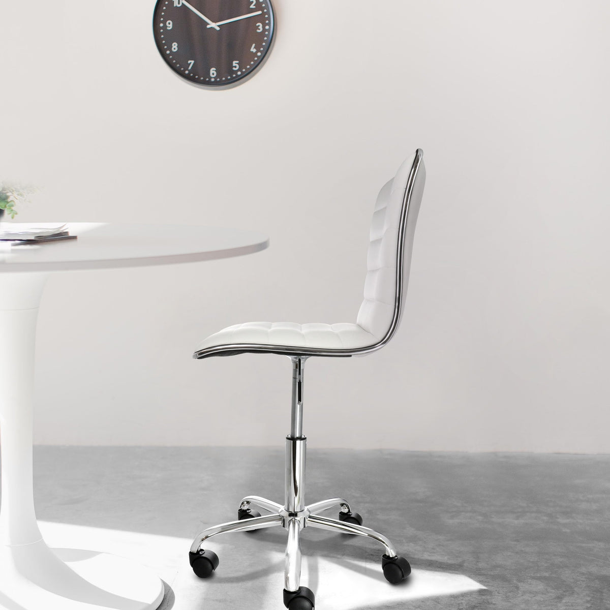 Elama white striped armless rolling chair at a round white table, lifestyle in a bright dining or meeting space