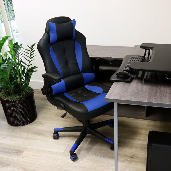 Elama black and blue faux leather gaming chair, lifestyle at a home office desk with a plant and keyboard tray