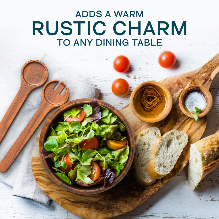 Laroda acacia wood salad bowl and servers on a dining table with bread, tomatoes and olive oil in a styled serving scene