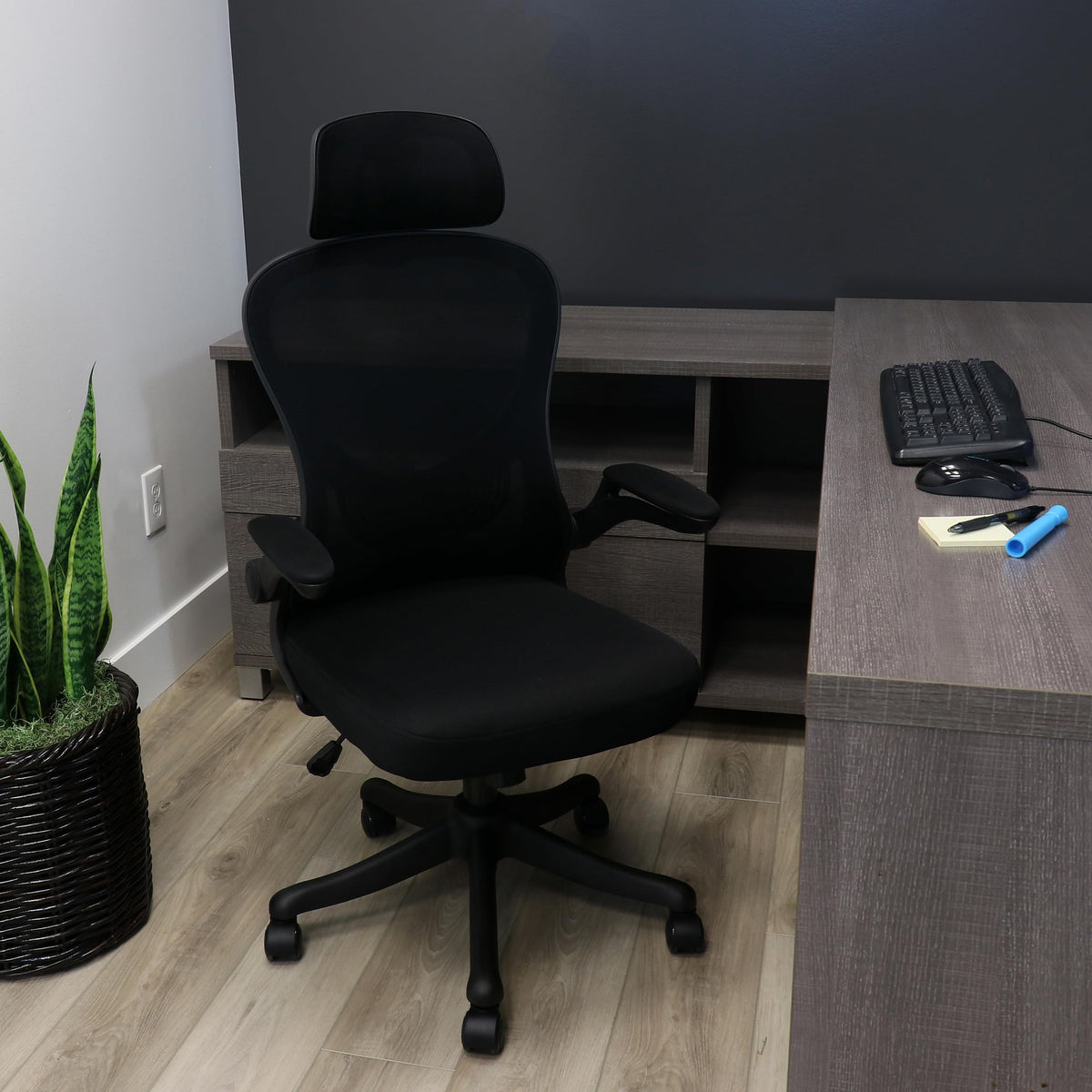 Elama black and gray ergonomic mesh office chair, lifestyle at a home office corner desk with a keyboard and plant