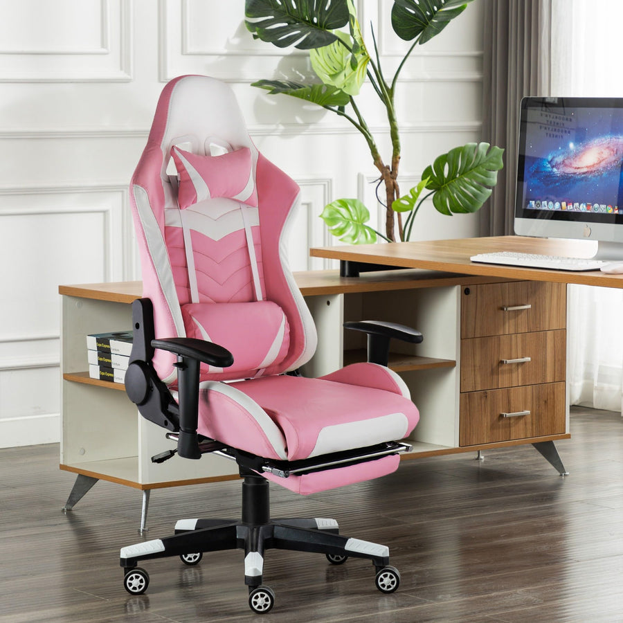 GameFitz pink and white gaming chair with footrest extended, lifestyle at a home office desk with a monitor and plants