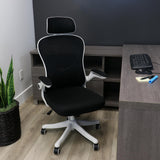 Elama white and black ergonomic mesh office chair, lifestyle at a home office corner desk with a keyboard and plant