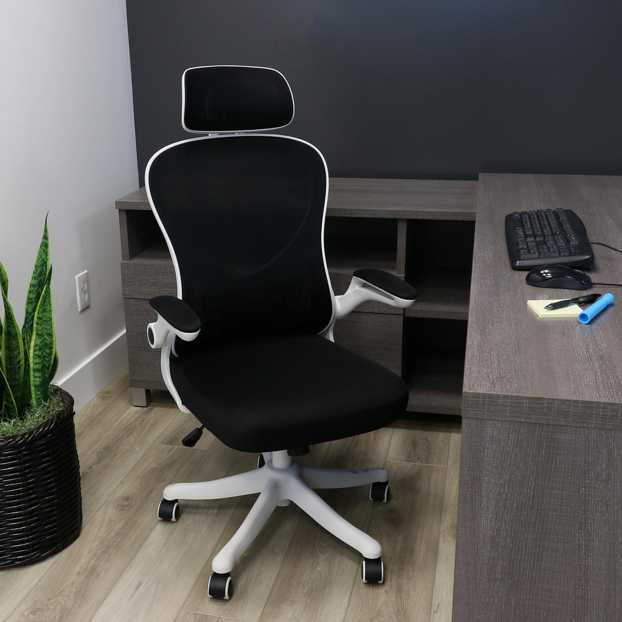 Elama white and black ergonomic mesh office chair, lifestyle at a home office corner desk with a keyboard and plant