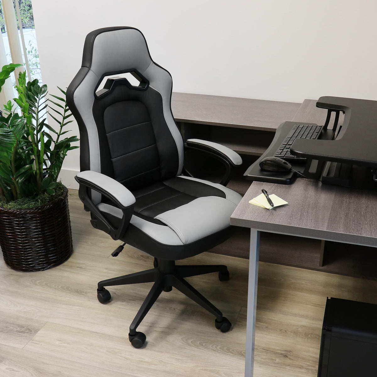 Elama high back faux leather office chair in gray and black with padded arms and ventilated back, lifestyle at a home office desk