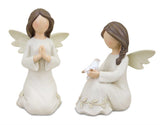 Two kneeling white and beige angel figurines with raised floral vines, one praying and one holding a white dove