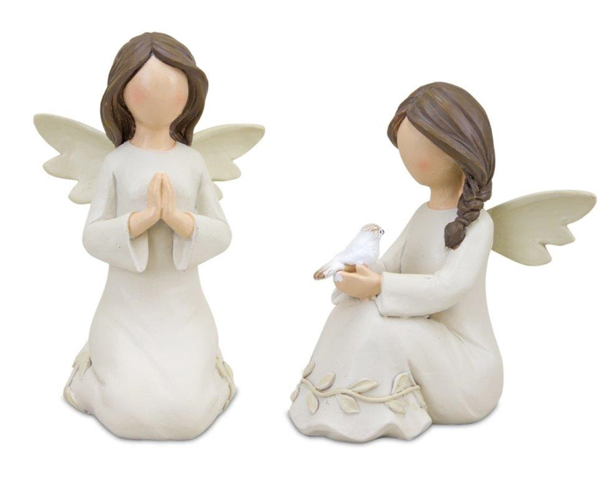 Two kneeling white and beige angel figurines with raised floral vines, one praying and one holding a white dove