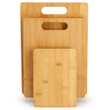 Three bamboo cutting boards with carved handles standing upright