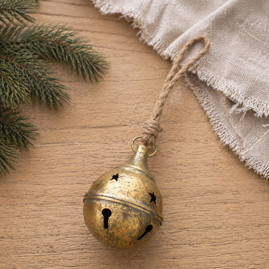 Distressed Gold Metal Sleigh Bell Christmas Ornaments hanging on a Christmas tree, holiday decor styling idea
