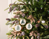 Ceramic Pine Tree Disc Christmas Ornaments hanging on a Christmas tree, holiday decor styling idea