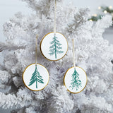 Ceramic Pine Tree Disc Christmas Ornaments hanging on a Christmas tree, holiday decor styling idea