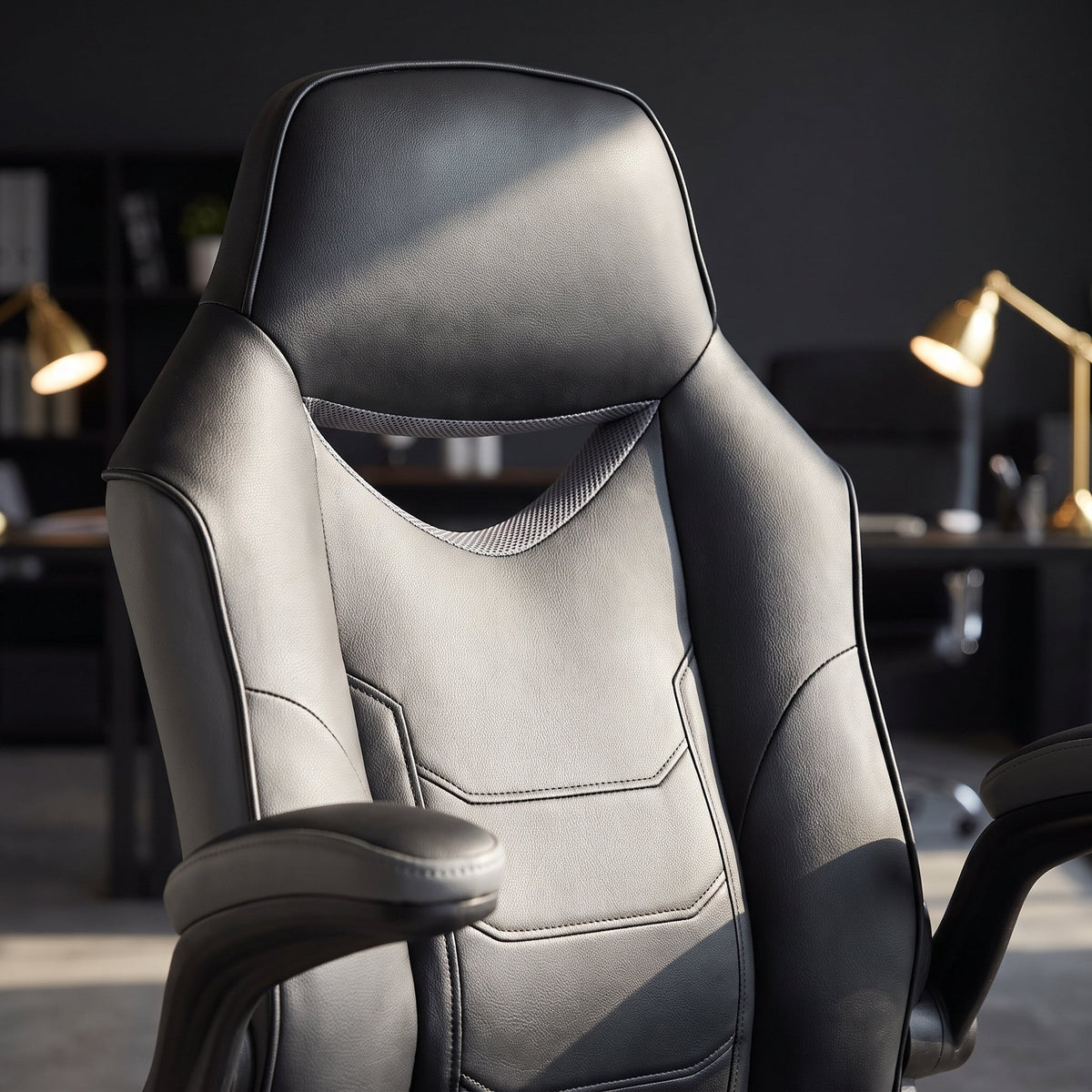 Close-up of a black and gray faux leather office chair backrest with stitched racing panels and vented upper back, Elama