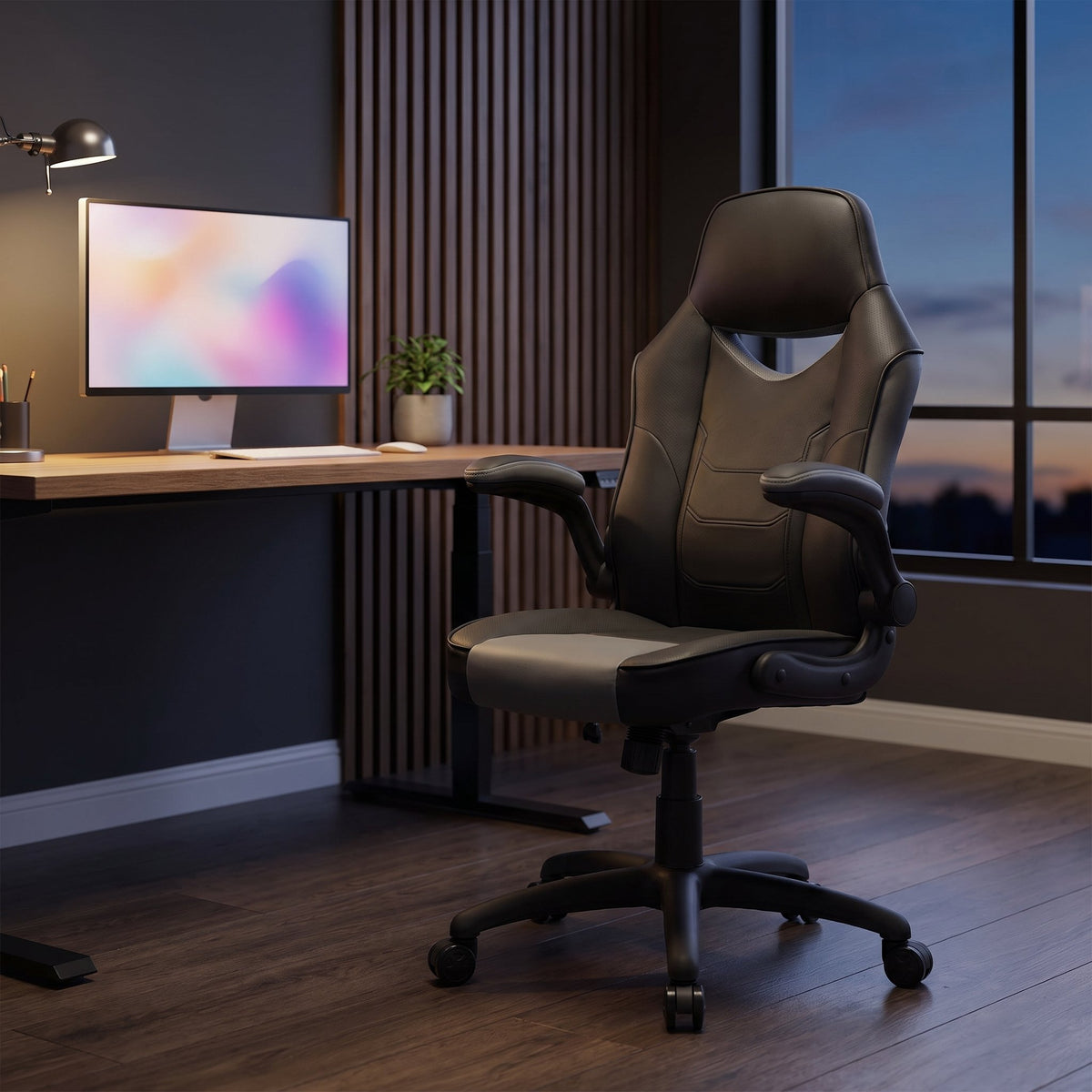 Elama black and gray high back office chair with flip-up arms at a desk in a modern home office with wood slat wall at dusk