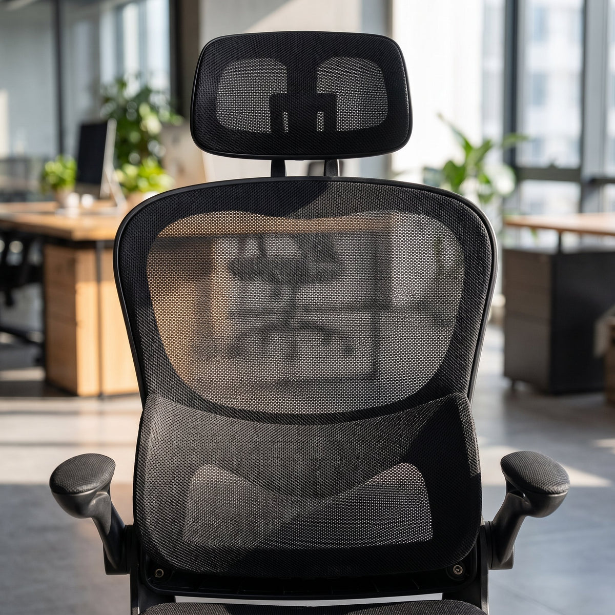 Close-up of an ergonomic mesh office chair headrest and breathable mesh backrest with lumbar curve, Elama black desk chair