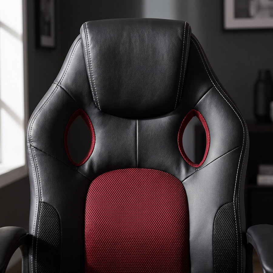 Close-up of a black faux leather office chair backrest with burgundy mesh center panel and two vent openings, Elama