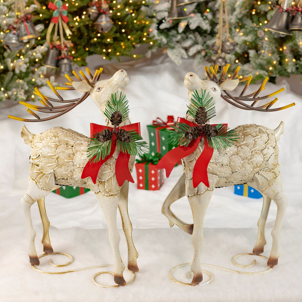Pair of hand painted iron reindeer with red metal bows, holly wreaths, and pinecones