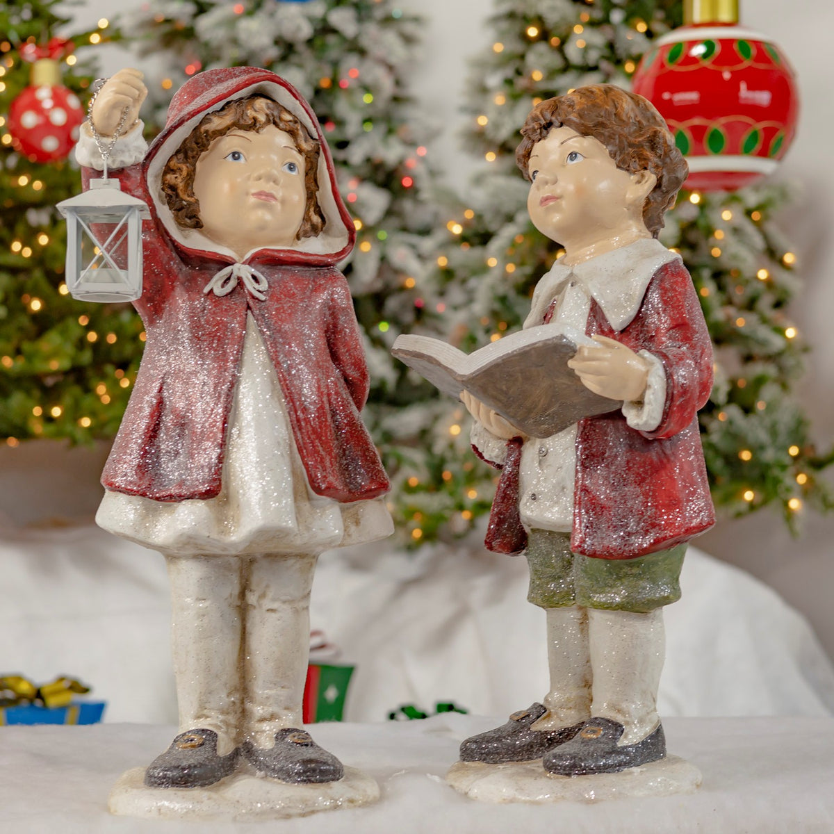Set of 2 hand painted Christmas tushka figurines in red cloaks sharing a book by a lantern