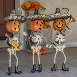 Set of three hand painted iron pumpkin head skeleton mariachi figures with maracas, guitar, and trumpet