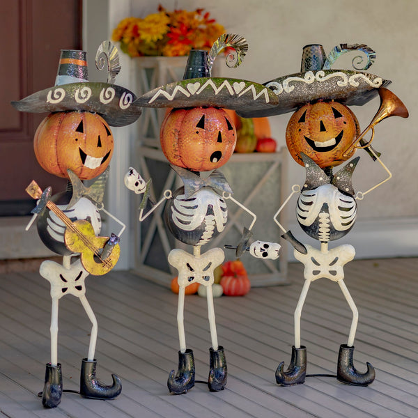 Set of three hand painted iron pumpkin head skeleton mariachi figures with maracas, guitar, and trumpet
