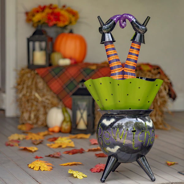 Metal Bewitched cauldron with a witch stuck upside down, legs sticking out, hand painted glossy finish
