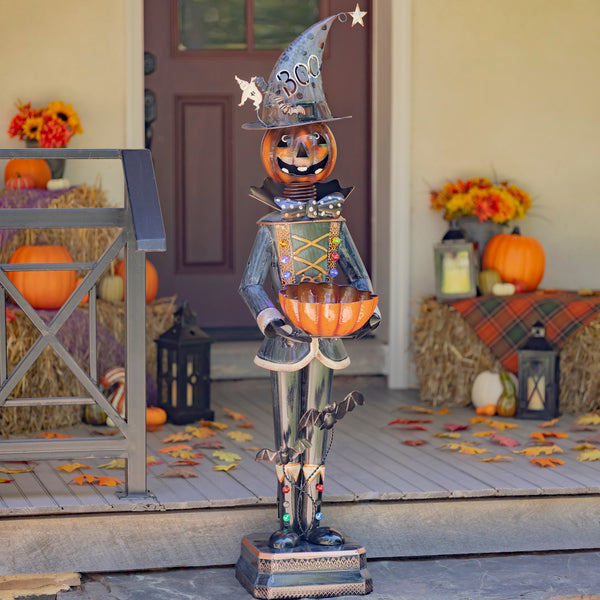 Tall metal pumpkin soldier holding a pumpkin candy bowl, with LED lights on his coat and boots