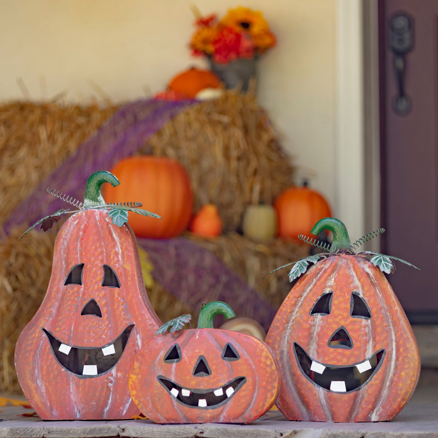 Set of three hand painted iron jack-o-lanterns in distressed antique orange with metal stems and leaves