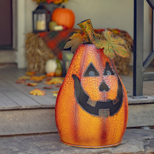 29 inch tall hand painted iron jack-o-lantern with a carved face and candle inside, distressed orange