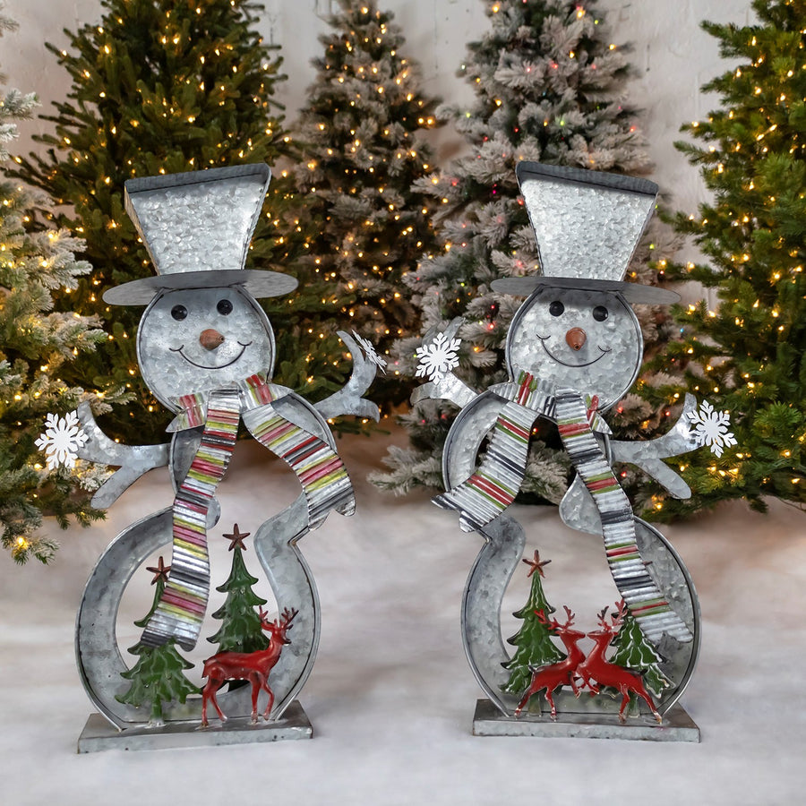 Two galvanized iron cookie cutter snowmen framing Christmas trees and reindeer, hand painted distressed finish
