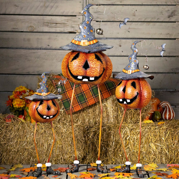 Set of three long legged iron jack-o-lanterns in black witch hats with flying bats, orange and black, three heights
