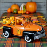 18 inch glossy orange and black metal Halloween pickup truck with jack-o-lanterns in the bed and a spider web on the windshield