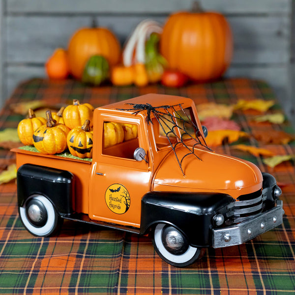 18 inch glossy orange and black metal Halloween pickup truck with jack-o-lanterns in the bed and a spider web on the windshield
