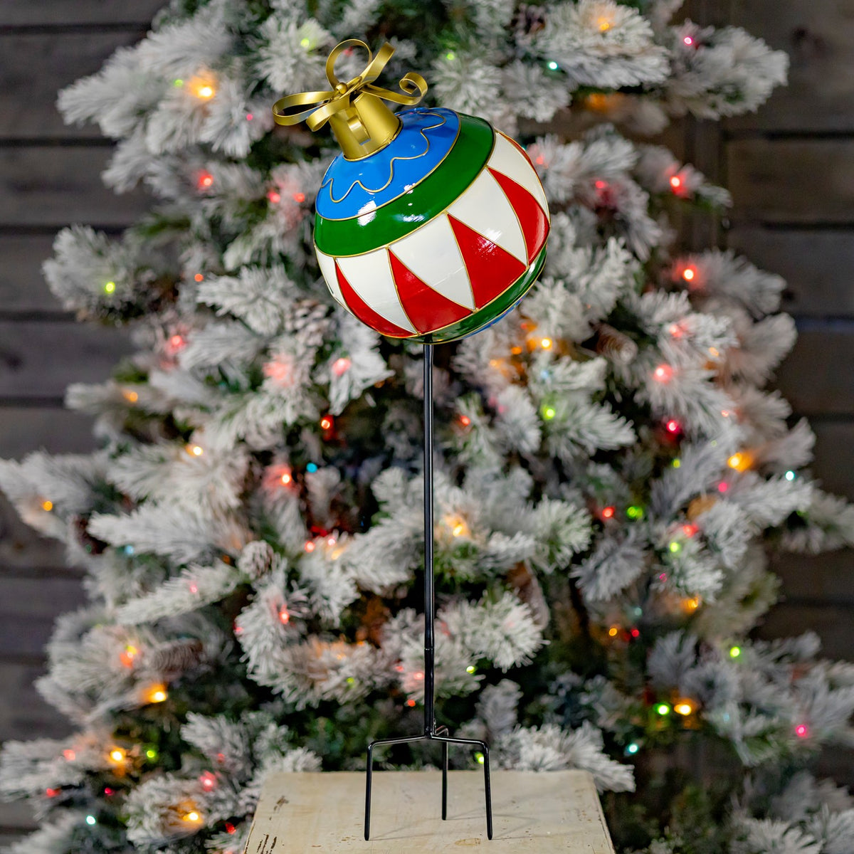 Iron Christmas ball ornament garden stake painted blue, green, red, and white with gold trim and bow
