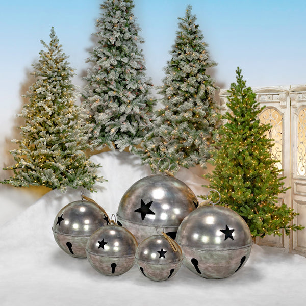 Set of five hanging antique silver iron sleigh bells with star cutouts in graduated sizes, hung by manila rope