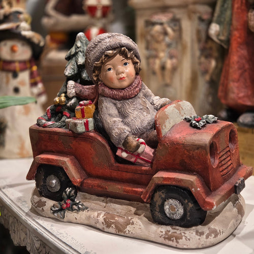 19 inch vintage style boy in a red truck with a Christmas tree and colorful gifts on a snowy base, hand painted polyresin