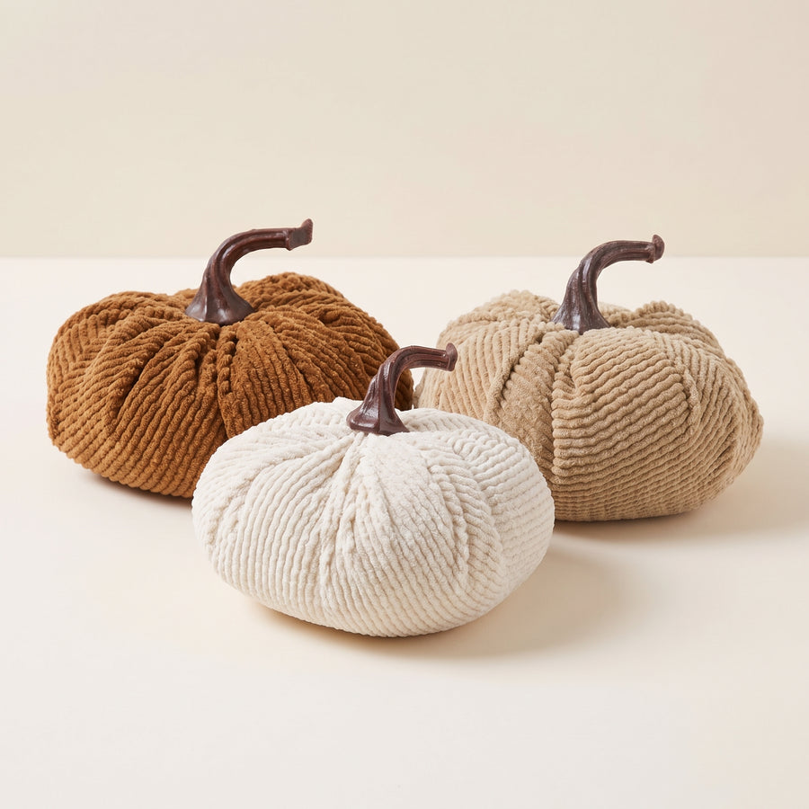Three plush corduroy pumpkins in white and brown with twisted rope stems in assorted sizes, raised studio angle on a plain surface