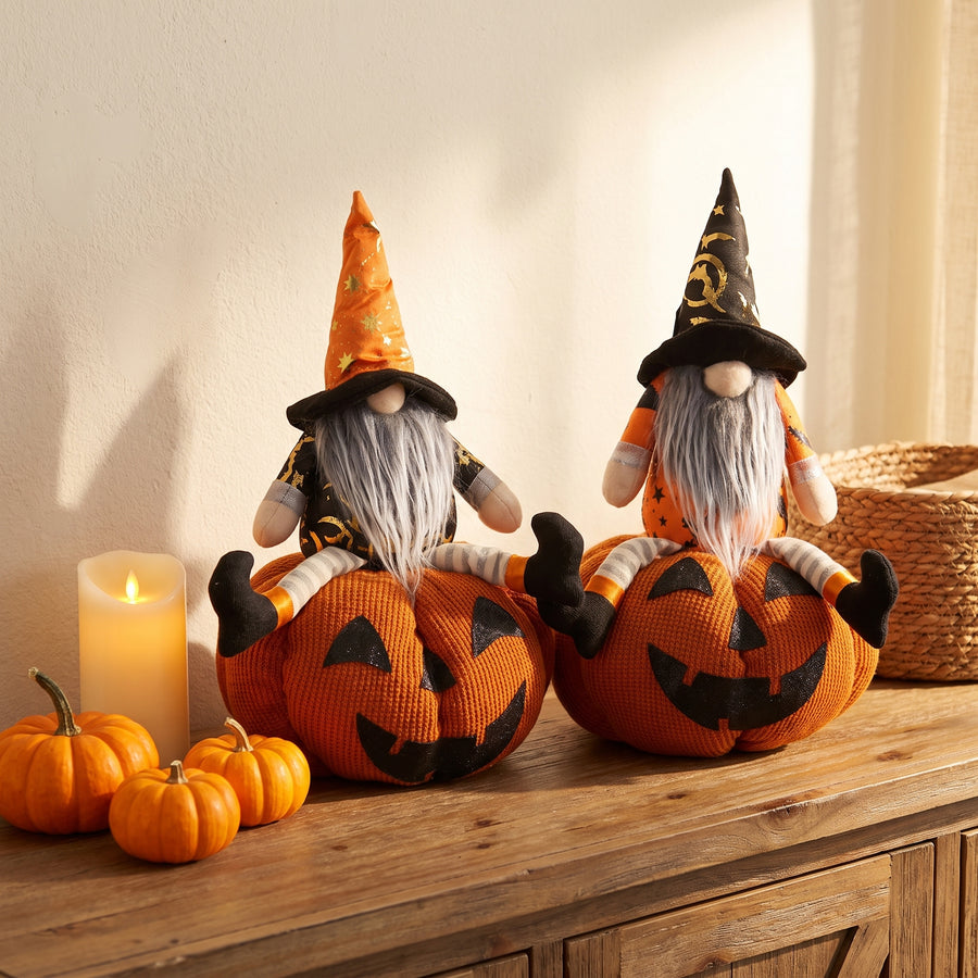 Two plush gnome-on-pumpkin characters on an entry console with mini pumpkins for Halloween