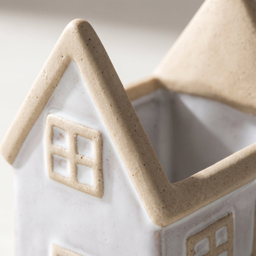 Macro of a porcelain house planter showing matte glaze, molded roof and window detail