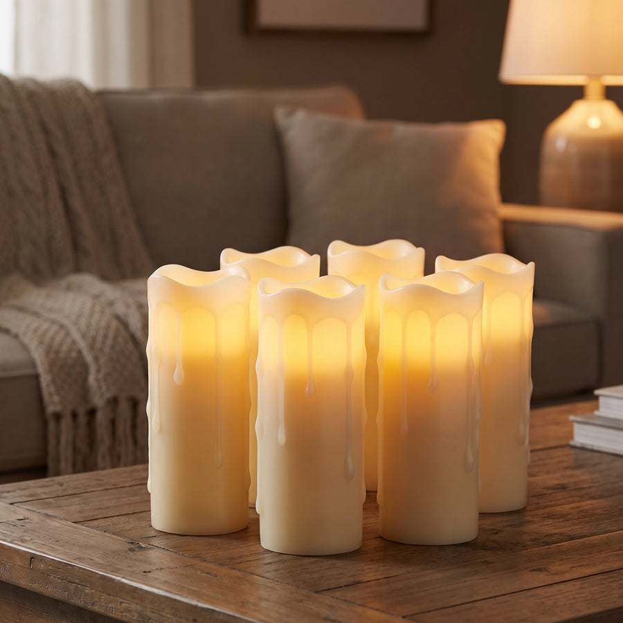 Set of six slim flameless pillar candles glowing together on a coffee table in a cozy evening living room