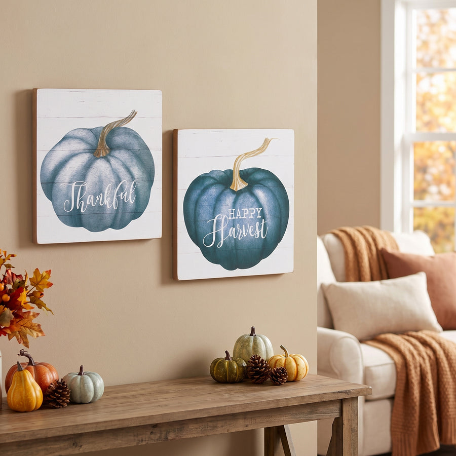 Two square white pumpkin sentiment signs hung on the wall above a console in a serene fall living room