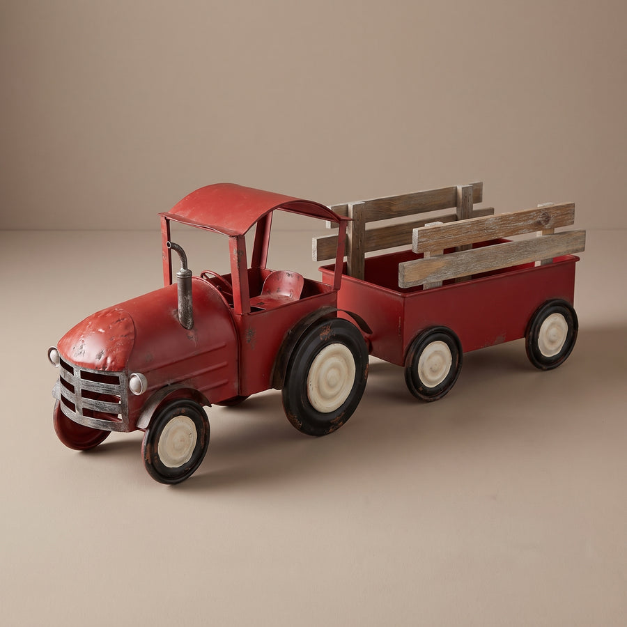 Red iron toy-style tractor with a wooden wagon about twenty-seven inches long, raised studio angle on a plain surface
