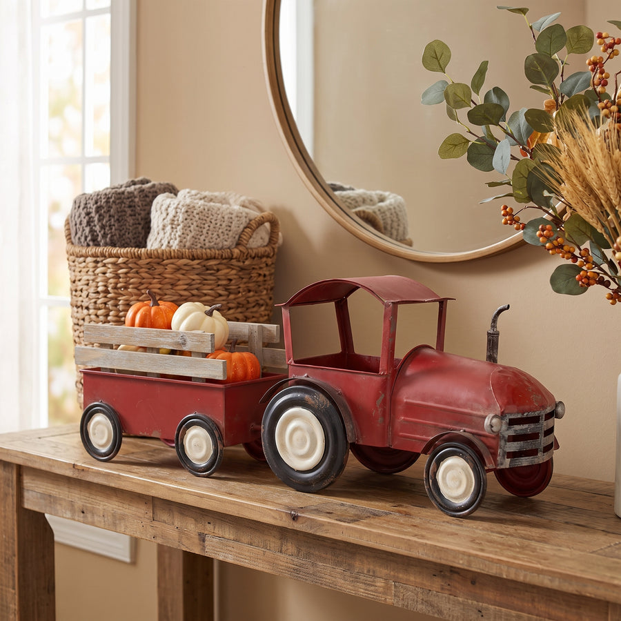 Red iron tractor and wooden wagon displayed on a console in a warm farmhouse entryway