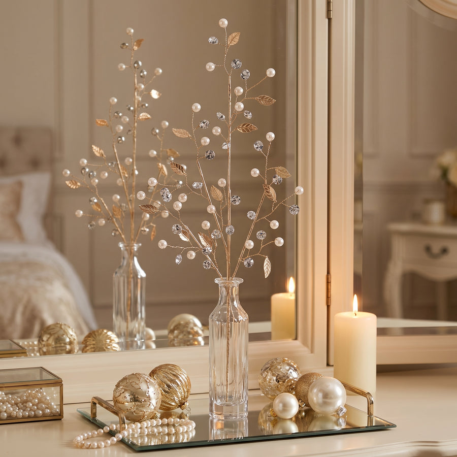 Pearl and gold leaf sprays in a crystal bottle vase on a mirrored tray with pearls at Christmas