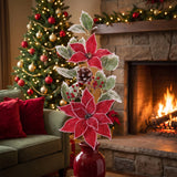 Red poinsettia and frosted holly Christmas sprays in a red vase on a hearth in a traditional living room