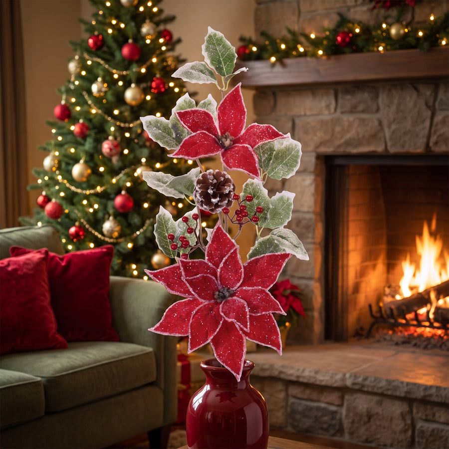 Red poinsettia and frosted holly Christmas sprays in a red vase on a hearth in a traditional living room