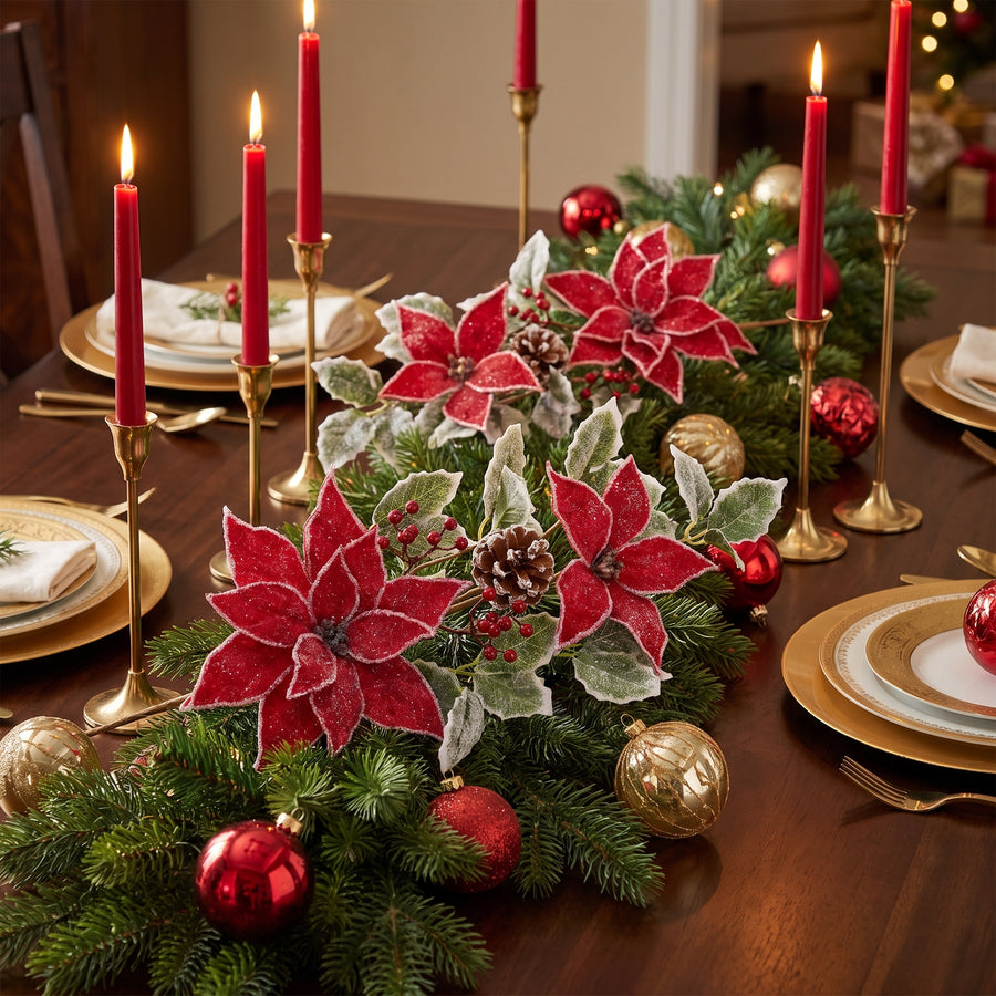 Poinsettia and holly sprays with pinecones and berries in an evergreen table garland with red candles