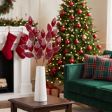 Two-tone red frosted leaf Christmas sprays in a white vase in a red and green living room