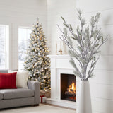 Frosted long needle pine bundle in a white floor vase in the corner beside a Nordic Christmas fireplace